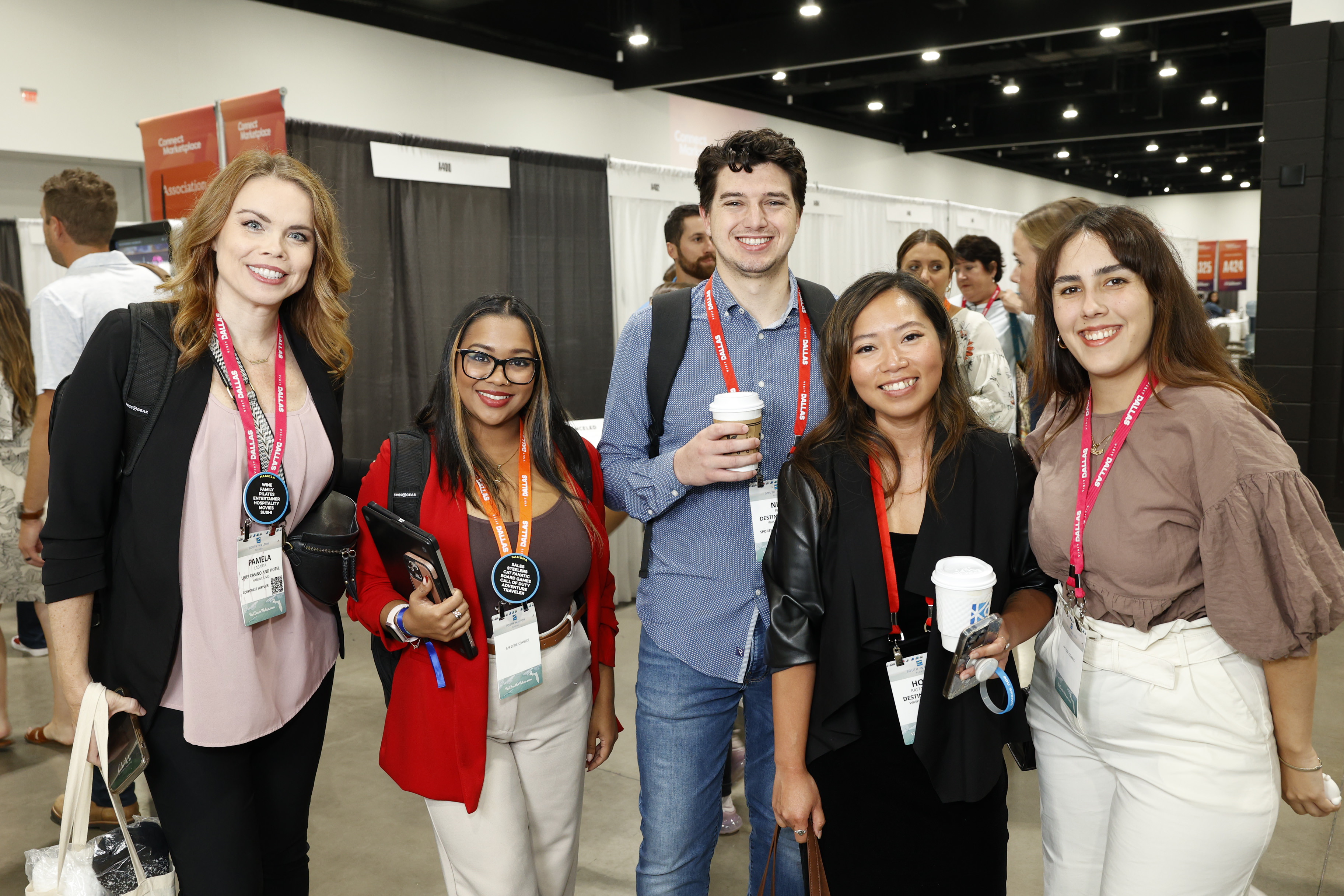 A group of event professionals smiling together before heading to marketplace appointments.