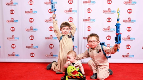 Three kids in ghostbusters cosplay pose on the red carpet