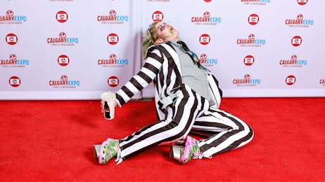 A fan in cosplay poses on the red carpet