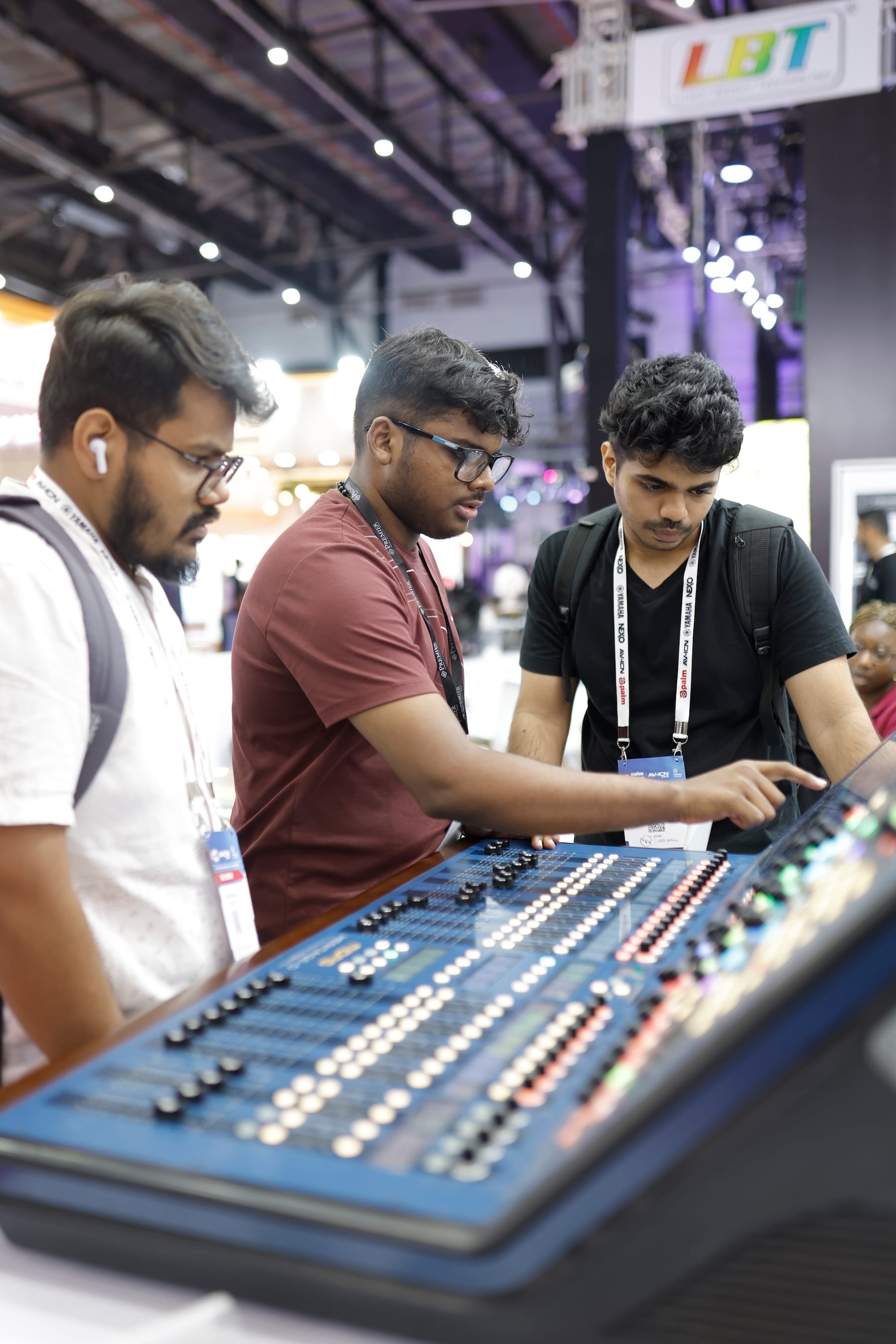 A technician explaining to two other technicians how a new sound mixer works
