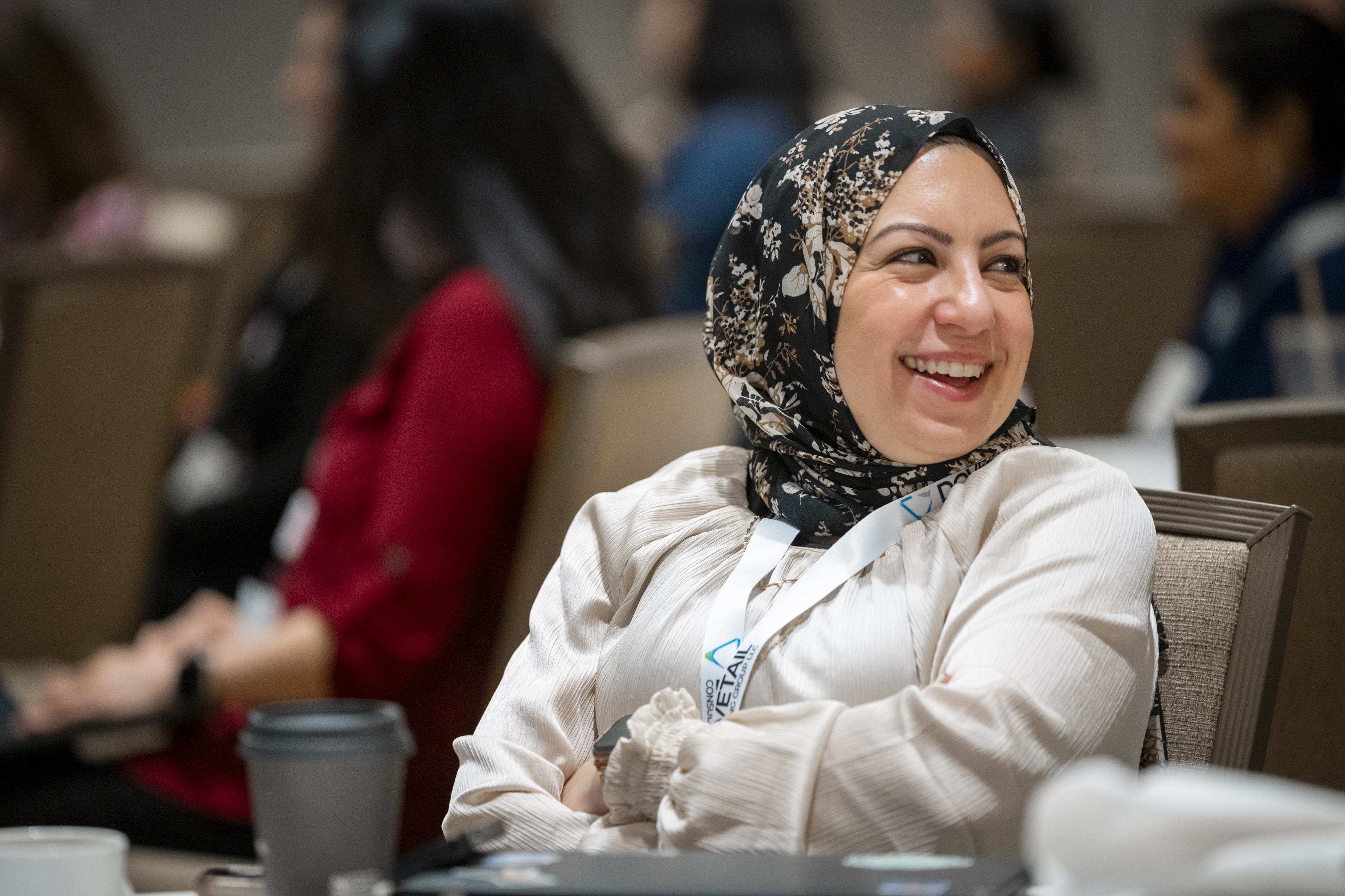 One attendee smiles as she sits on a chair.