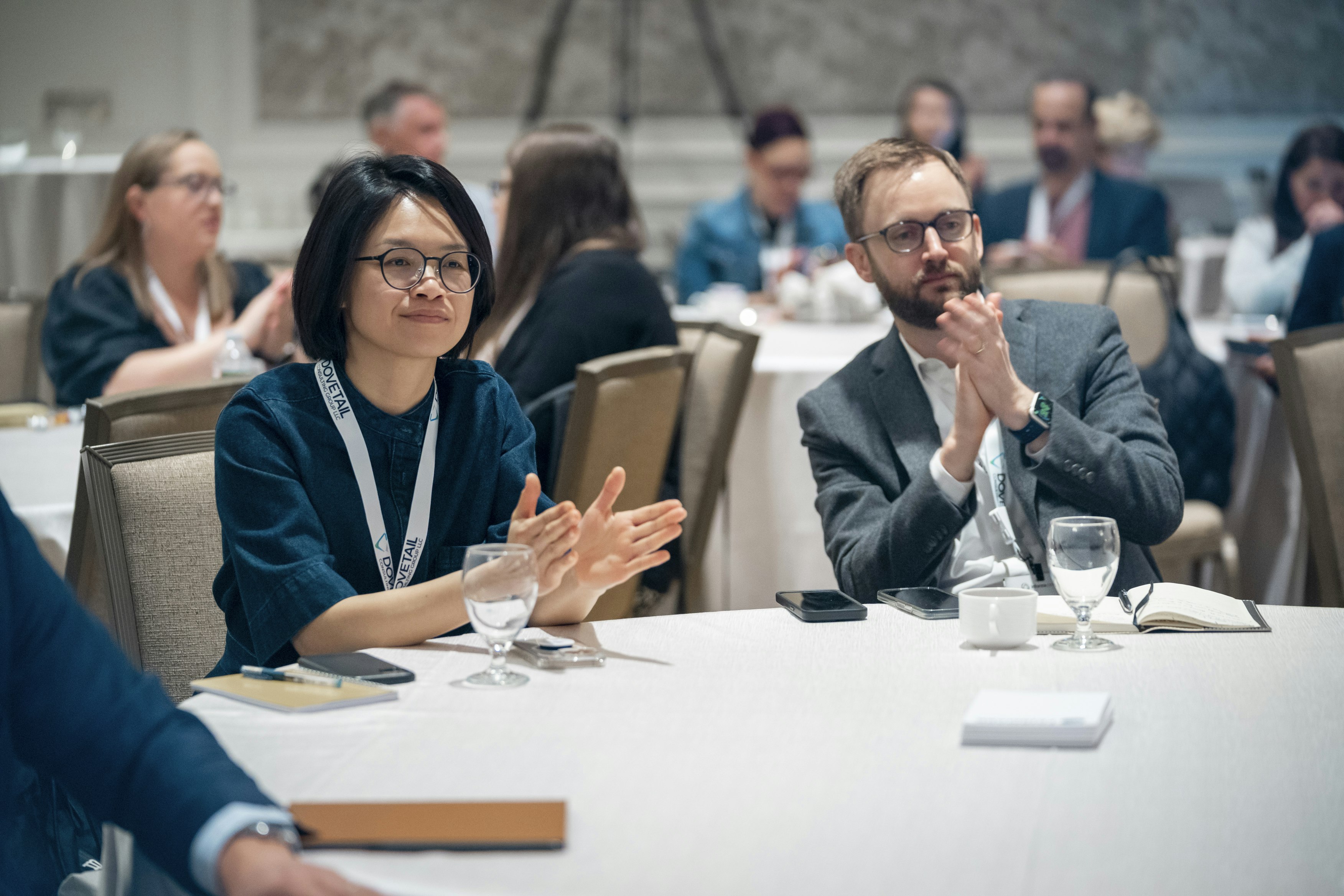 Attendees at Transparency & HCP Engagement clap as they sit round a table.