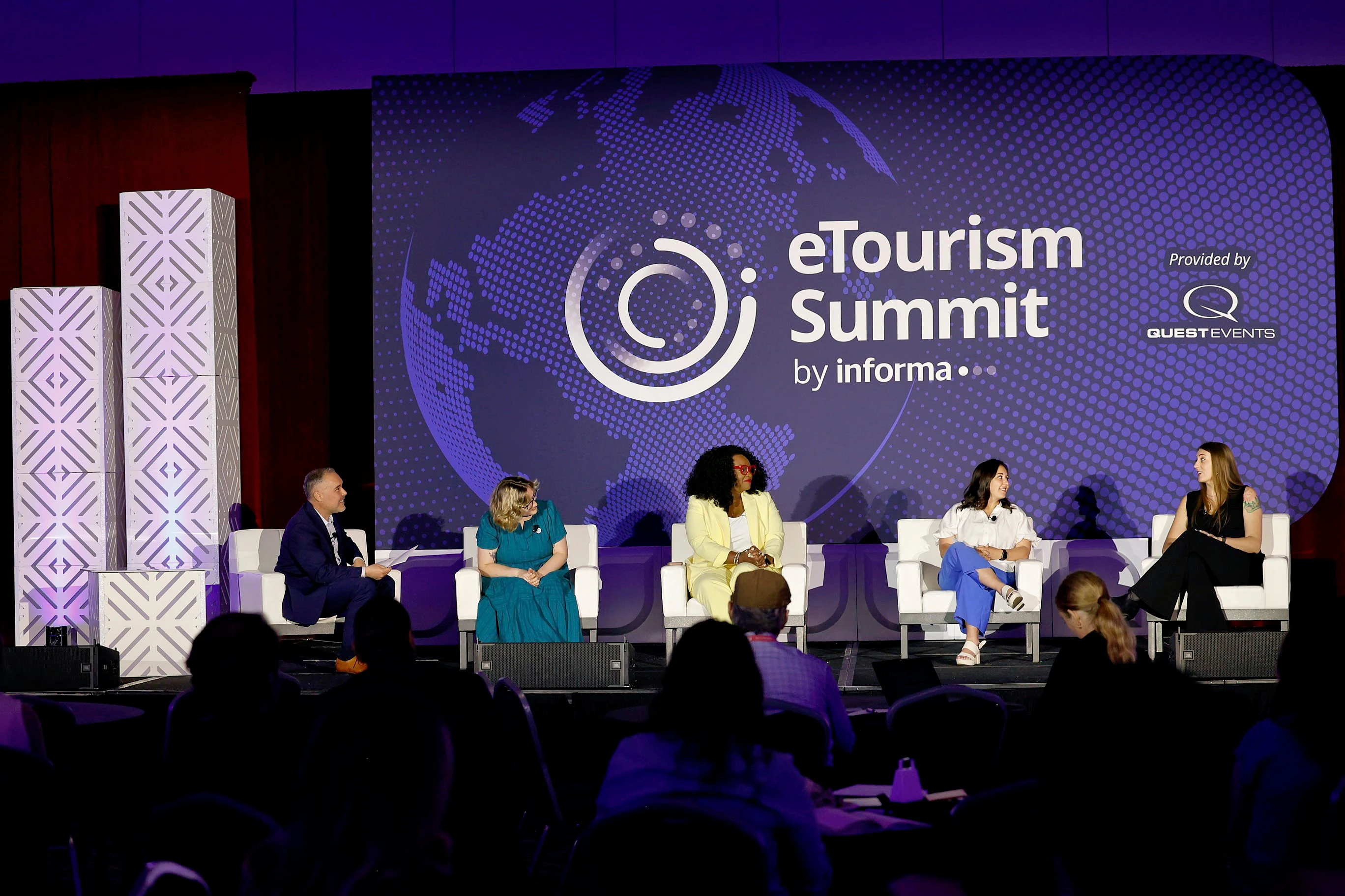 A man and a woman standing on stage at eTourism Summit holding their eTSY Award.