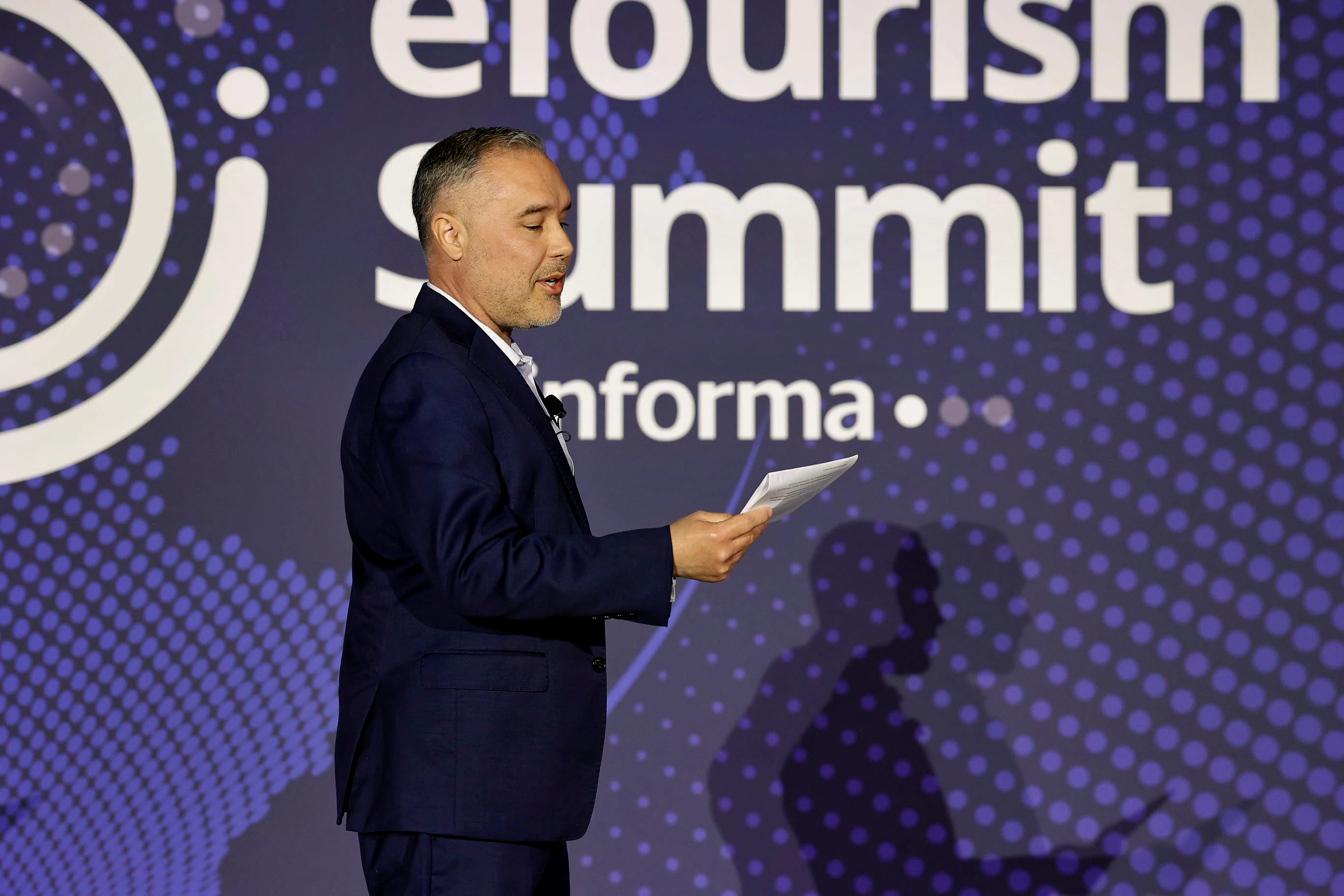 A woman with red hair in a black dress shaking hands and accepting an award from a man in a black suit.