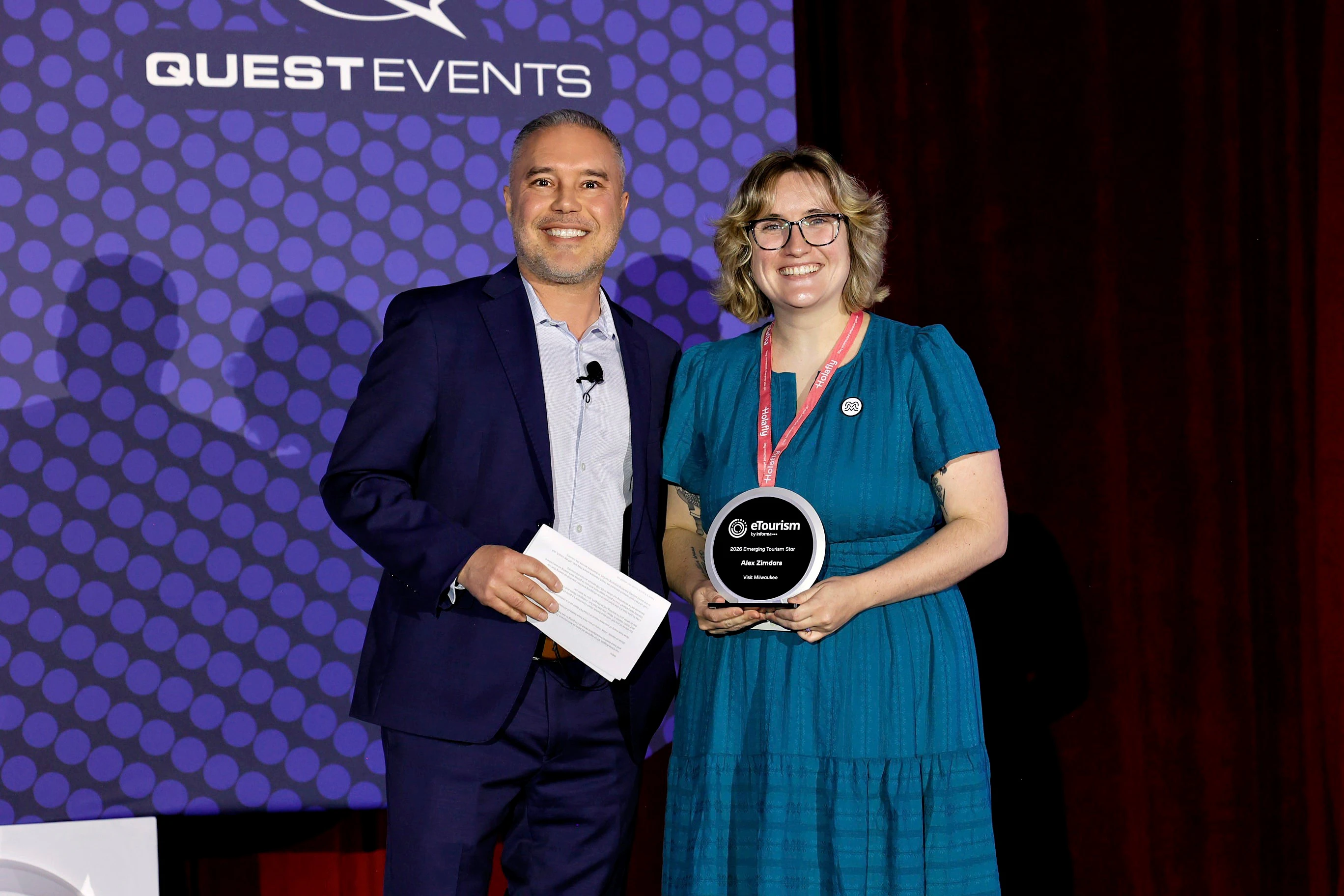 A woman accepting an eTSY Award from a man wearing a black suit.
