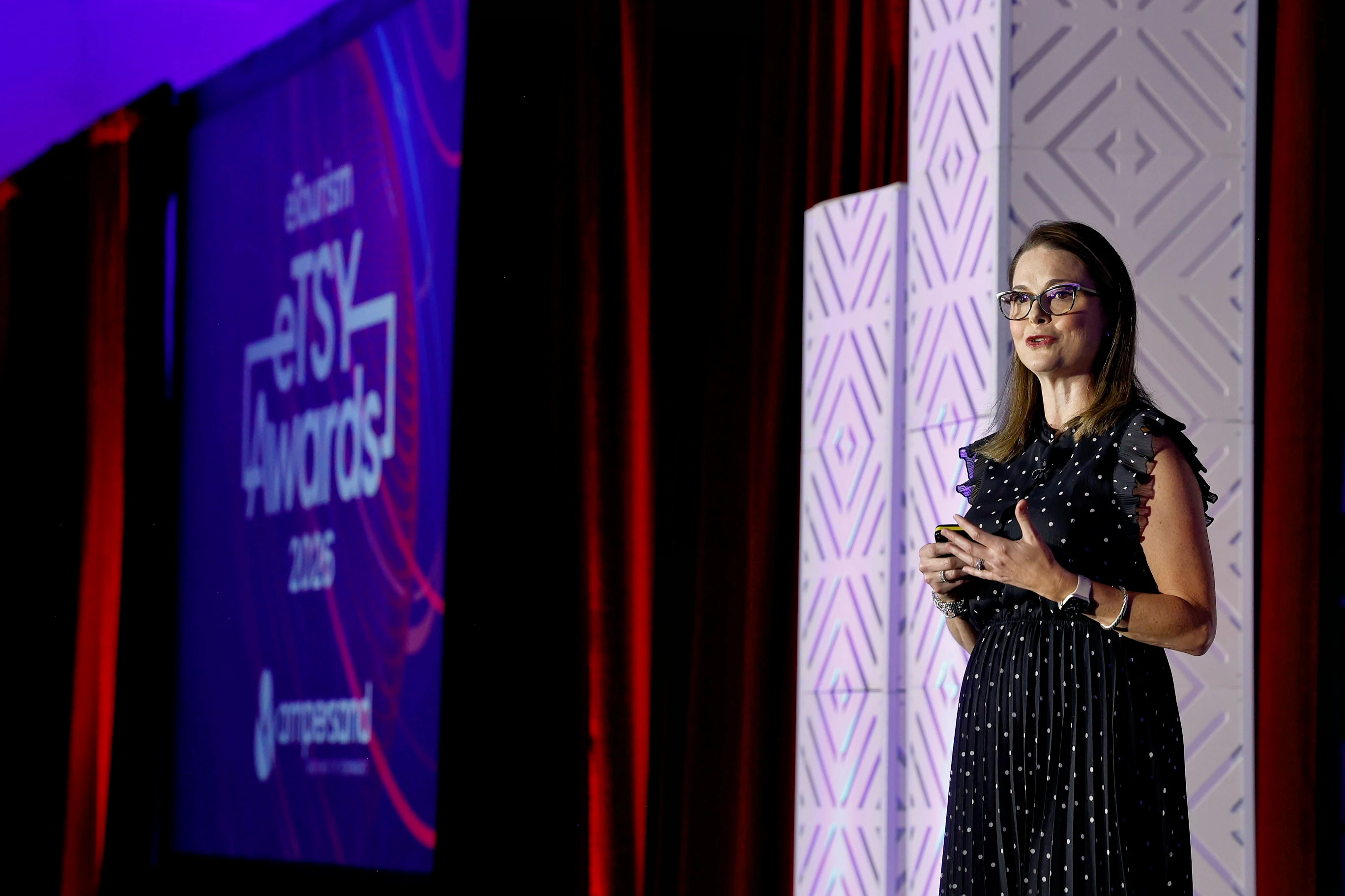 A woman accepting an eTSY Award from a man wearing a black suit.