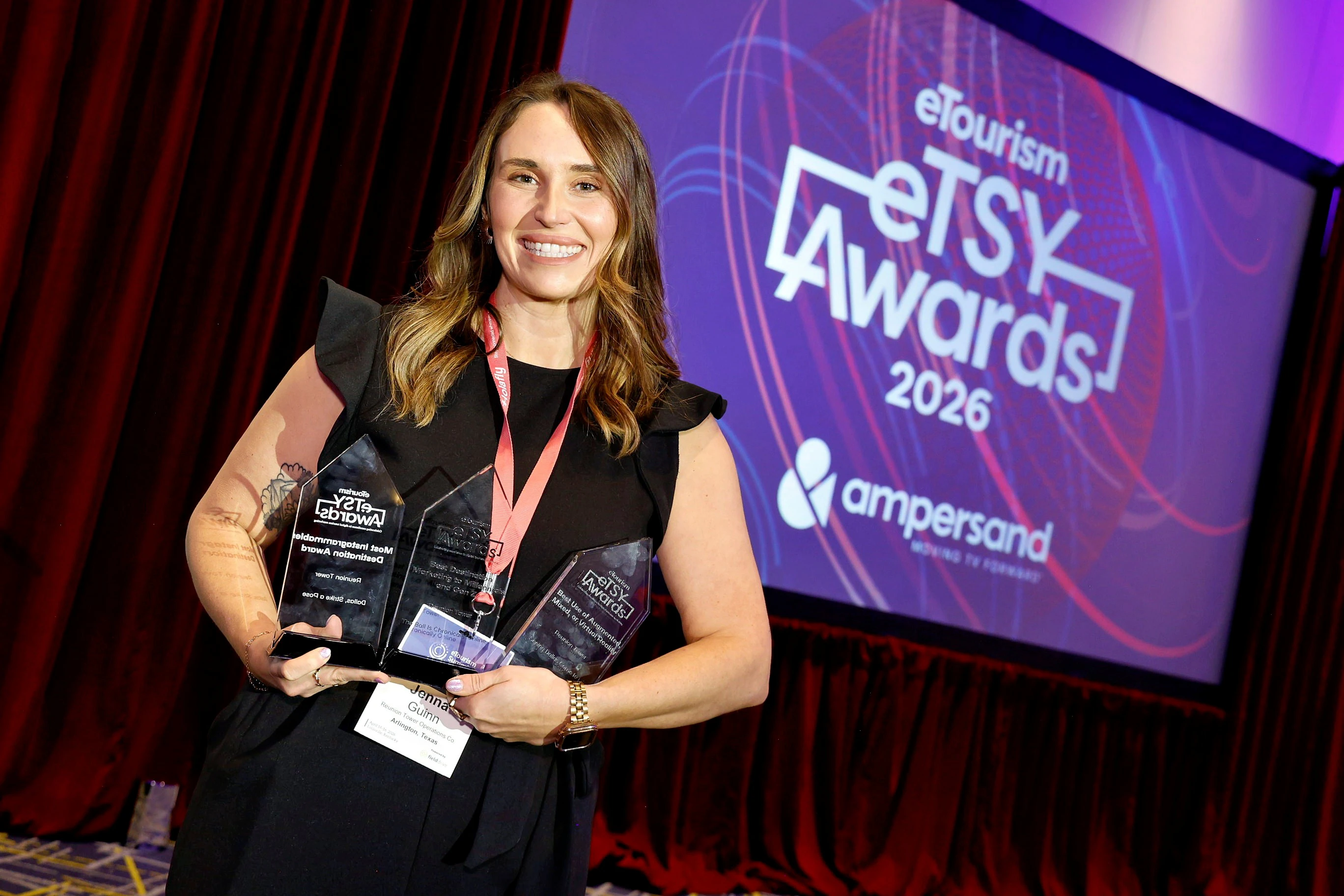 Four women on stage at eTourism Summit smiling and posing for the camera.