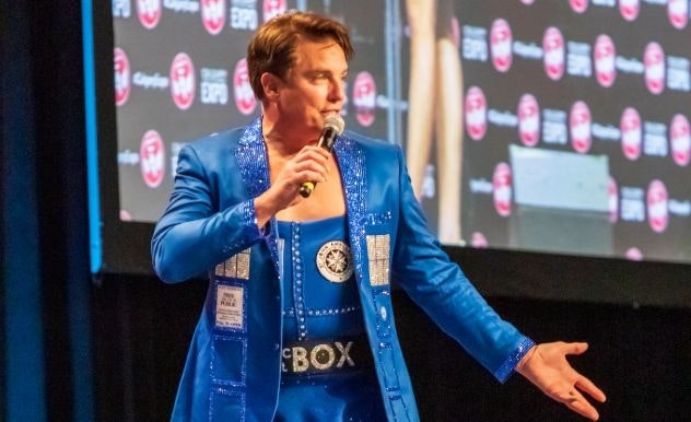 John Barrowman stands in a blue TARDIS jacket