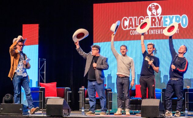 hobbits on stage waving around cowboy hats