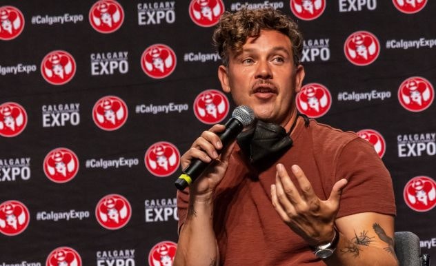 Kevin Michael Alejandro wears a red shirt and speaks into a microphone