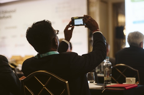 Attendee photographing a presentation at World Ethanol & Biofuels 2025, capturing insights on markets, policy, and sustainability trends.