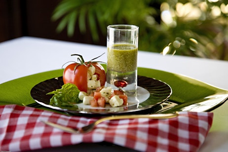 caprese salad inside a tomato with pesto sauce