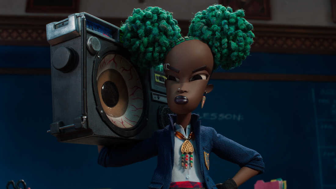 A screen cap of the protagonist of Wendell & Wild, Kat Elliot (voiced by Lyric Ross). Here, she holds a boombox while standing in a classroom.
