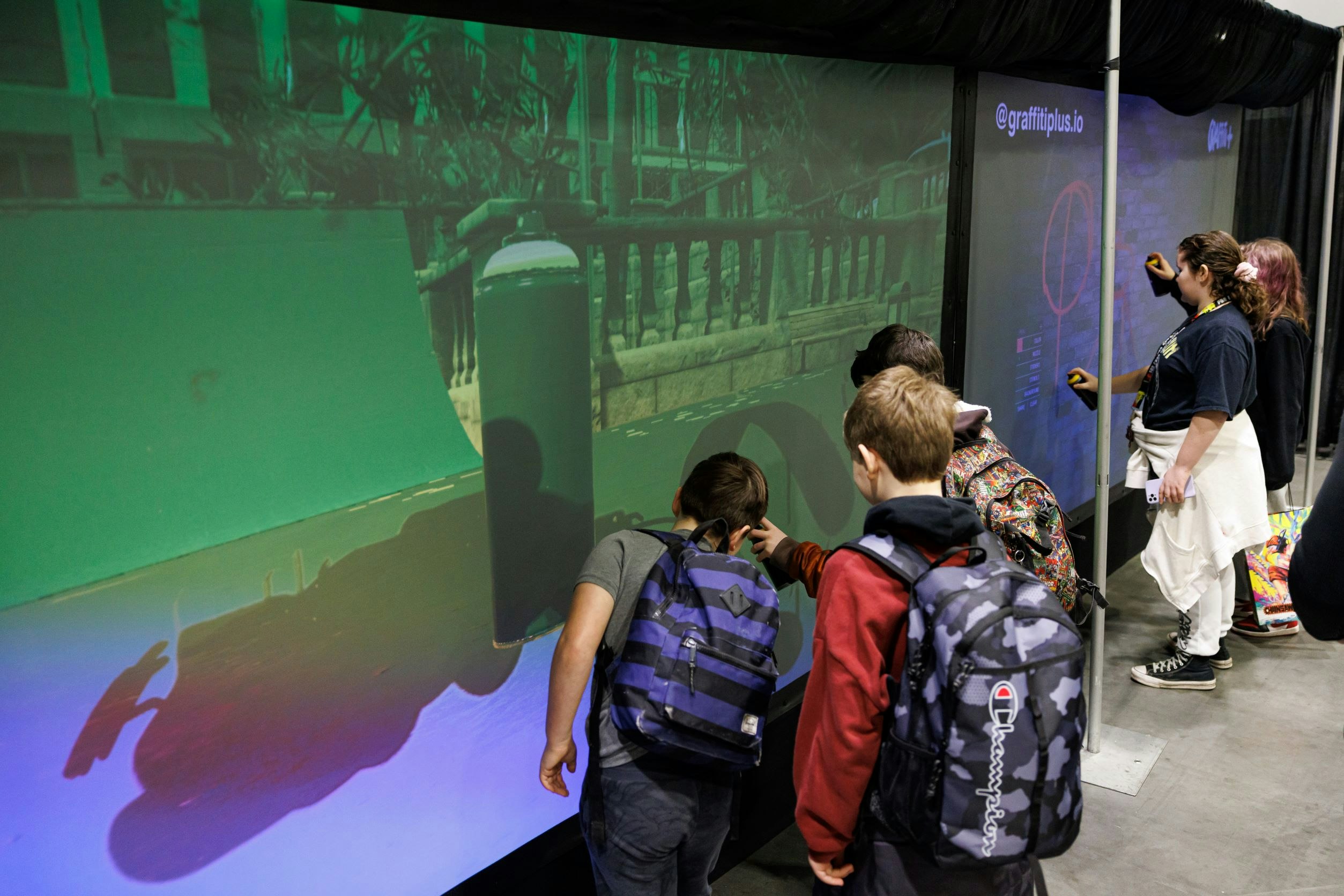 Kids participating in the graffiti art wall installation