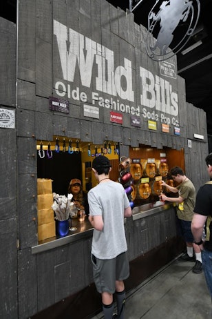 Fans visit the Wild Bill's booth, purchasing and filling cups with one of their many old fashioned sodas.