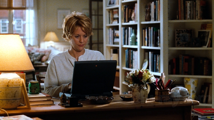 Kathleen Kelly (Meg Ryan) using her computer in her apartment.