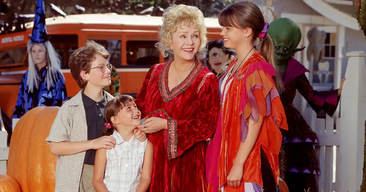 Several of the main characters of Halloweentown standing together. From left to right: Dylan Piper, Sophie Piper, Agatha Cromwell, and Marnie Piper.