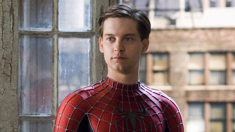 Spider-Man (Tobey Maguire) in his Spidey outfit without the mask, standing in his apartment looking at someone off camera