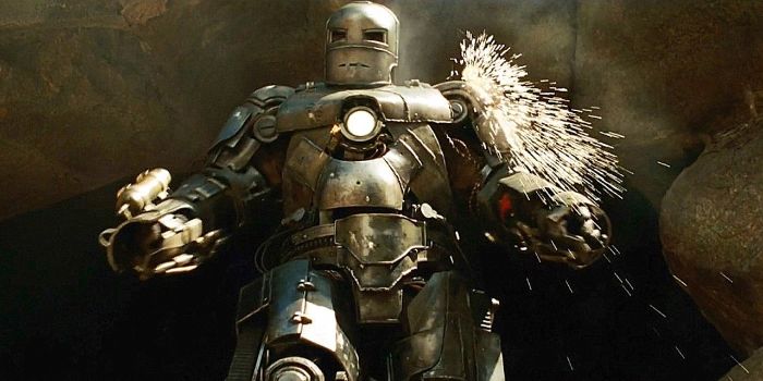 clunky first ever iron man suit emerging from cave getting shot at showering sparks
