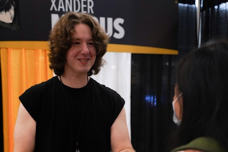 Xander Mobus smiles while interacting with a fan