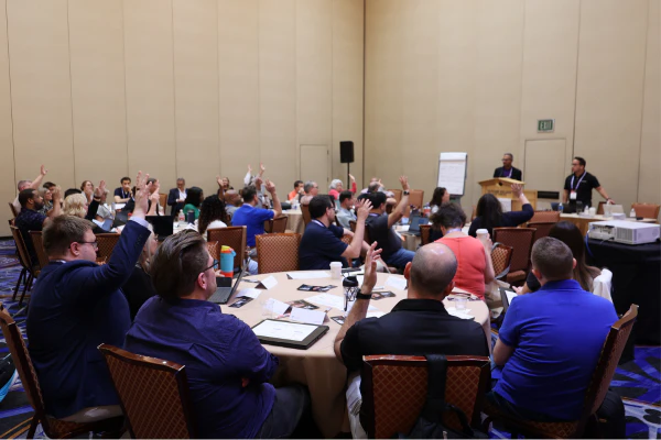 Attendees raise their hands during an interactive workshop session at HDI Service & Support World.