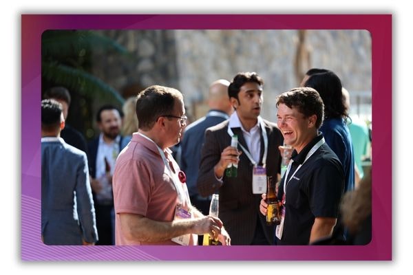 Three men stand and talk outside during a networking event