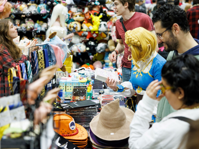 Fans shopping at booth with hats and other costume pieces