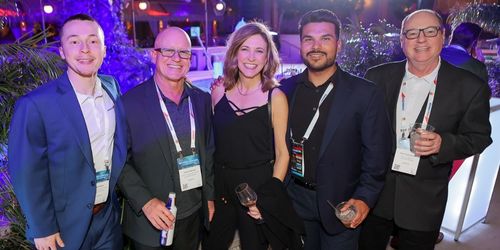 A photo of five people smiling for the camera at a networking event