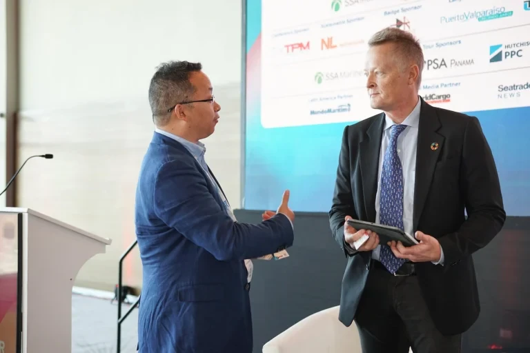 Two attendees having a discussion in front of an exhibitor display.