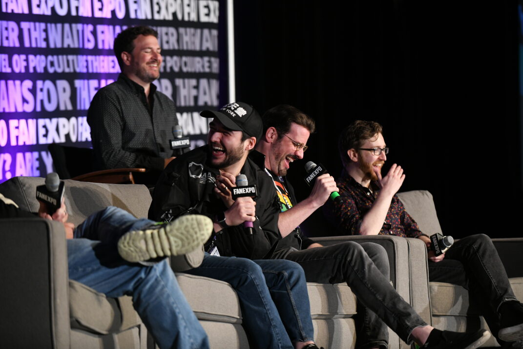 Chris Wehkamp, Brandon McInnis, J. Michael Tatum, and Justin Briner laugh as Christopher Sabat makes a joke for the audience.