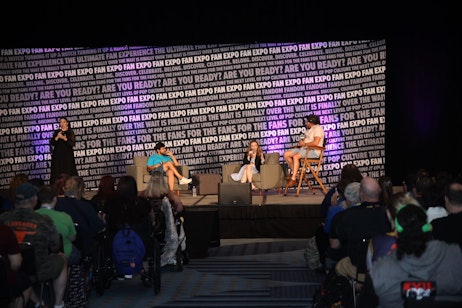 Carlos Valdes and Danielle Panabaker answer fan questions during thair panel on the maine stage. Moderator Victor Dandridge listens intently, and the interpreter shares Danielle's story using ASL