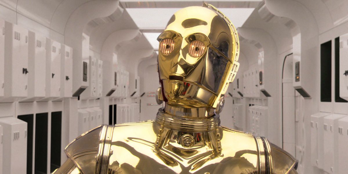C-3PO from Star Wars looks off to the distance, almost looking surprised, in a white hallway