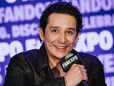 Gabriel Luna smiling and holding a microphone.