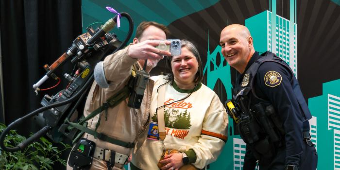 A GHOSTBUSTER GRABS A SELFIE WITH FRIENDS, ONE BEING A MEMBER OF THE PORTLAND POLICE FORCE