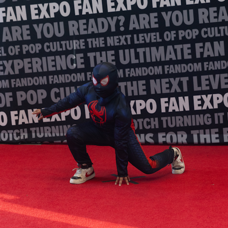 Miles Morales on the cosplay red carpet in a superhero landing pose