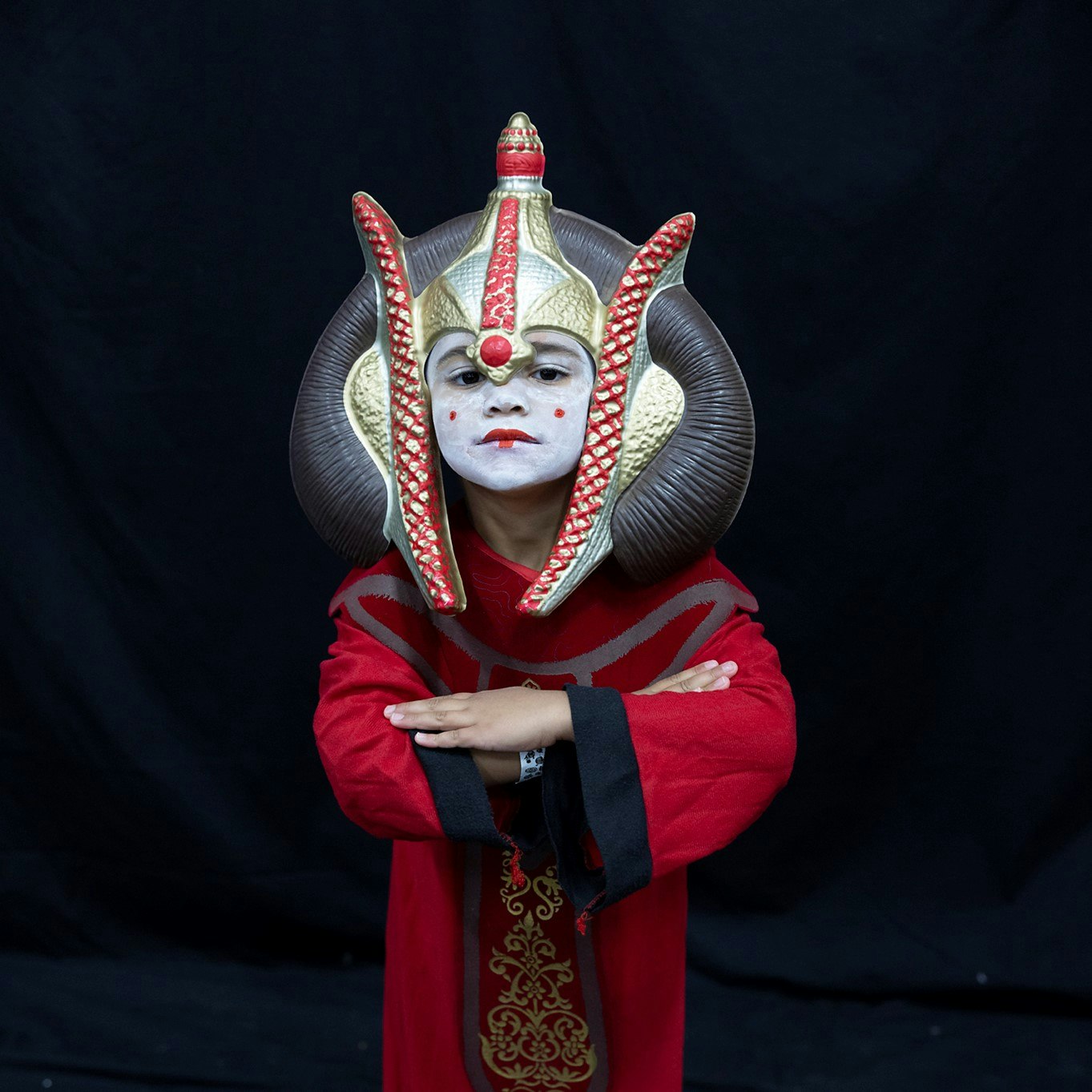 A little Padme Amidala poses on a black backdrop