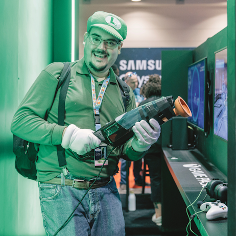 A fan dressed as Luigi presents his Poltergust G-00 before playing at the XBox booth.