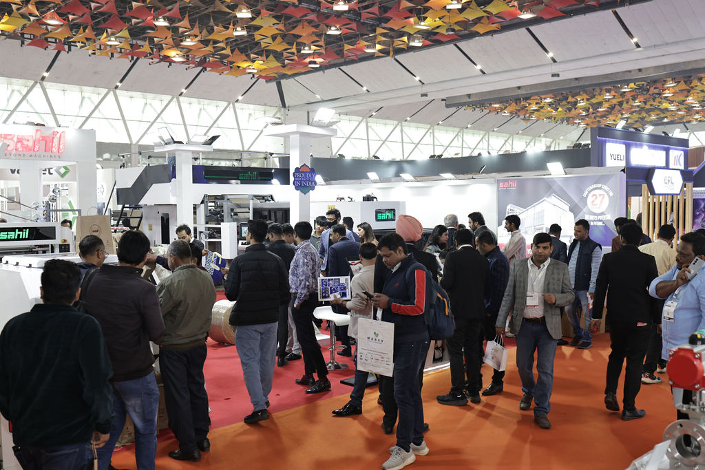 Attendees walking through the corridor, exploring various booths on display at Paperex