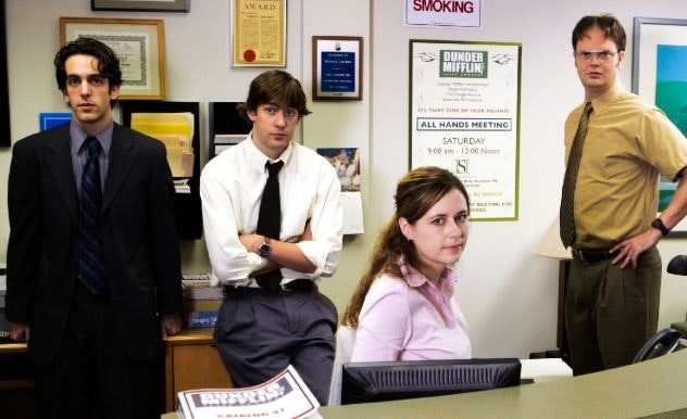 Some of the main cast of The Office (L-R: Ryan, Jim, Pam, Dwight) stand at a receptionist desk