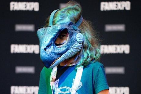 a young fan dressed in a velociraptor mask