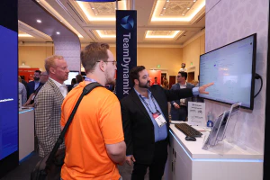 Conference attendee watching a live product demonstration from an exhibitor in the Expo Hall, exploring new technologies and solutions for IT service and support.