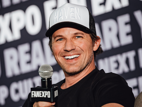 Matt Lanter smiling and holding a microphone.