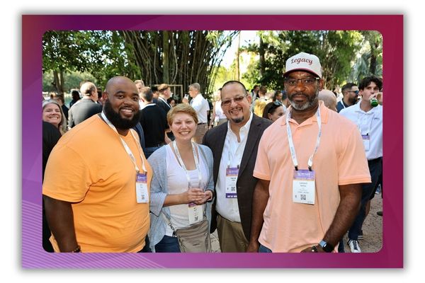 Four people standing outside and smiling at a networking event