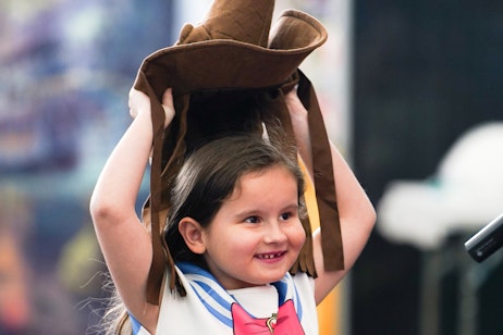 A young child puts on the Harry Potter sorting hat