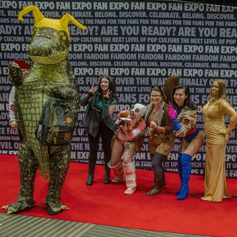 On the cosplay red carpet, blow up Alligator Loki taking a selfie with other cosplayers dressed and marvel characters