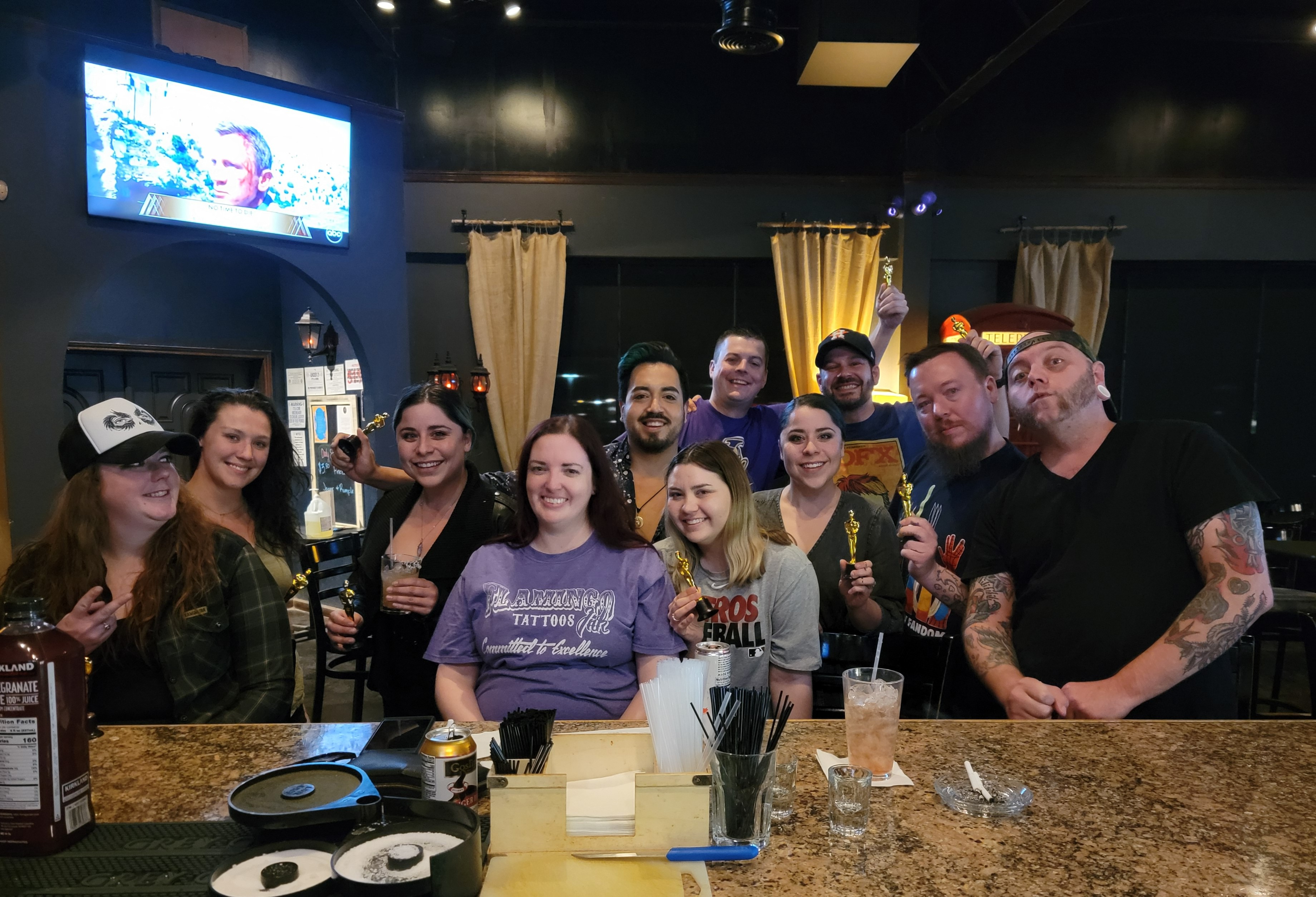 Group pic at a restaurant and everyone is holding mini-Oscar trophies