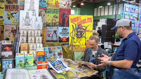 A fan is talking to a comic creator