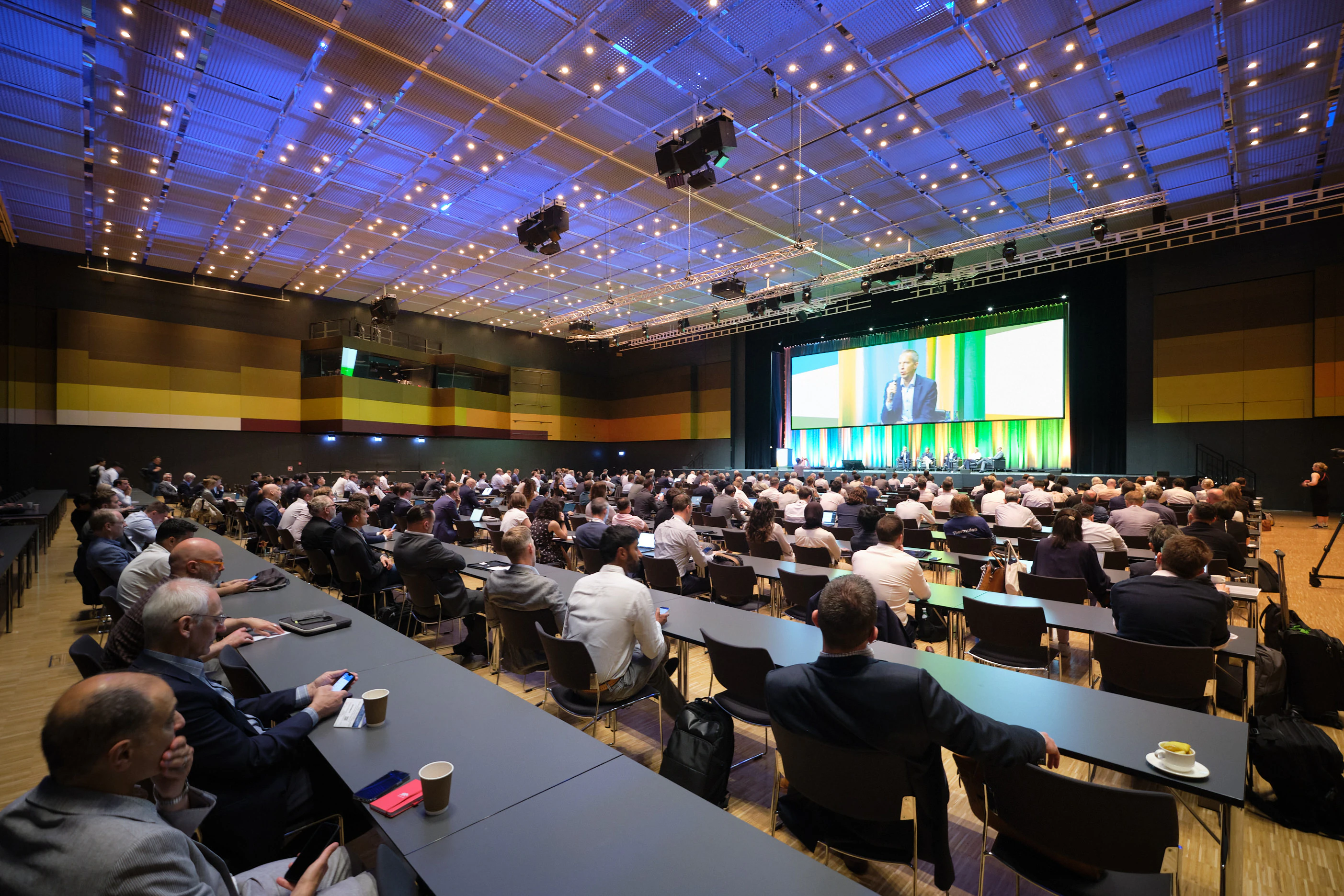 Numerous attendees gathered at tables in a conference venue