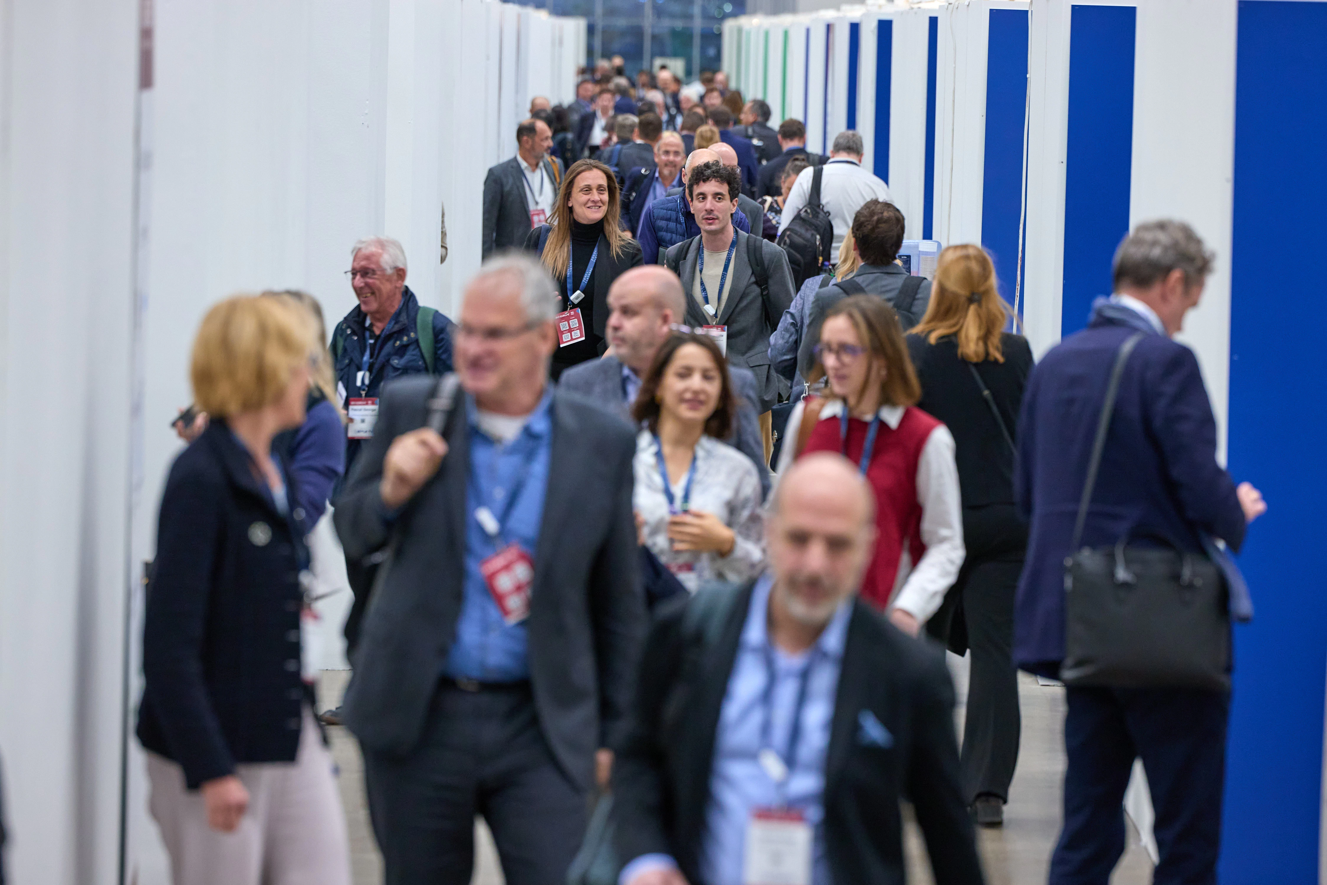 Event attendees walking down a busy aisle of partnering booths