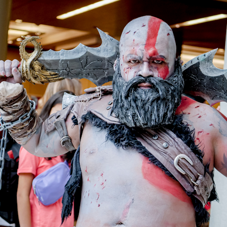 A Kratos cosplayer poses with his sword. 